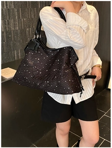 Sac fourre-tout noir à motif d'étoiles avec logo gaufré porté par un modèle