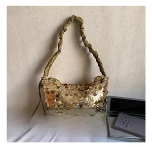 Detail showing shiny gold sequins and pleated shoulder strap of this fashionable bucket bag