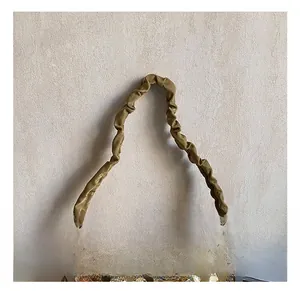 Close-up of golden sequin fabric and trendy scrunchie handle on luxury shoulder bag