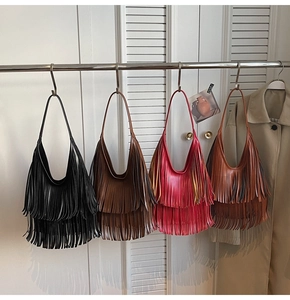 Bohemian fringe shoulder bags in multiple colors hanging on a modern display rack