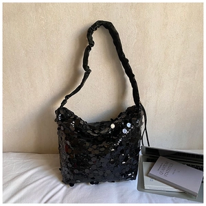 Detail of black sequin shoulder bag with textured scrunchie strap and reflective finish