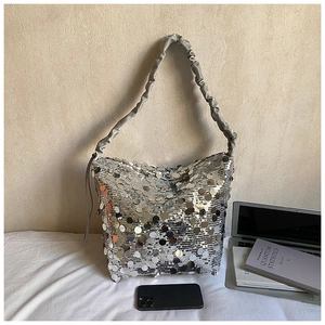 Close-up of sparkling silver sequins and pleated grey satin handle on fashion bucket bag