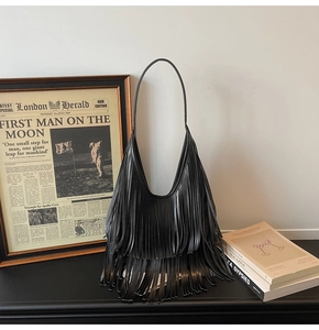 Chic black fringed bucket bag with multi-layer tassels and slim shoulder strap detail