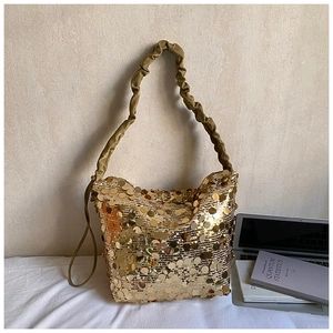 Detail of gold sequin tote bag featuring large round sequins and pleated shoulder strap