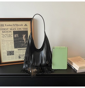Close-up of black layered tassel hobo bag with matte leather finish and shoulder strap
