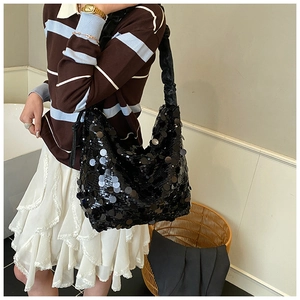 Close-up of black sequined shoulder bag with ruched wide strap and hobo design