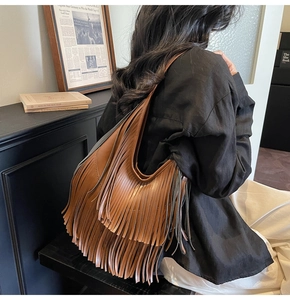 Close-up of brown bucket bag featuring layered long tassels in bohemian style