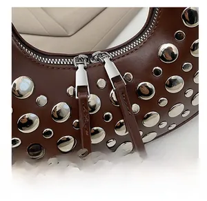Detail shot of the silver double metal zippers and rivets on the dark brown leather bag