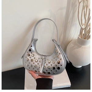 Detail of silver crescent bag with stud embellishments and dual zip closure