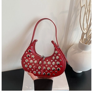 Macro detail of red hobo bag with metallic silver studs and double zipper closure
