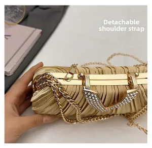 Détail de la bandoulière chaîne dorée amovible et du logo V en cristal sur le sac