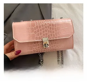 Close-up of pink faux leather snake pattern crossbody bag with silver metal swivel lock