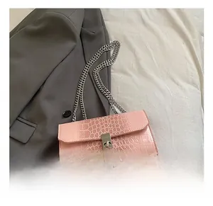 Detail view of pink crocodile texture PU leather handbag with silver chain and metal lock