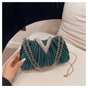 Détail de la pochette en satin vert émeraude plissé avec un logo V en strass