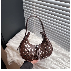 Detailed close-up of dark brown crescent bag with silver rivet studs and double zipper closure