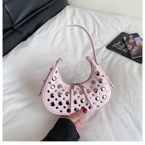 Pink crescent handbag detail showing silver rivet studs and dual zipper closure