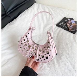 Detailed close-up of pink hobo bag featuring decorative silver studs and crescent shape