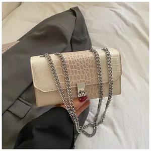 Detailed macro view of beige faux-crocodile embossed texture and silver square lock
