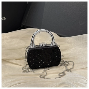 Détail du mini sac en velours noir avec clous argentés et poignée métallique incurvée