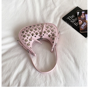 Detailed top view of pink saddle bag with decorative silver rivets and metal zipper closure