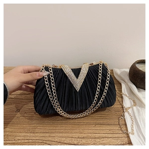 Détail du sac de soirée plissé noir avec boucle en V strassée et chaîne dorée