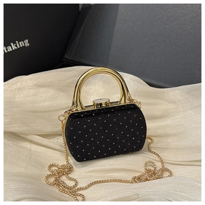 Détail de la pochette de soirée en daim noir avec strass dorés et poignée ronde