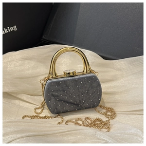 Détail du sac de soirée en velours gris avec strass argentés et chaîne dorée