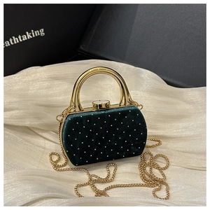 Détails du sac de soirée en velours vert foncé avec clous dorés et poignée en métal
