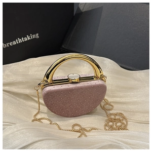 Gros plan sur une pochette en velours rose avec texture brillante et anse dorée