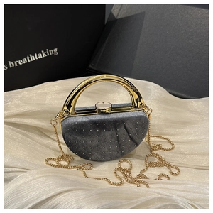 Détail du sac de soirée en velours gris avec strass brillants et poignée dorée