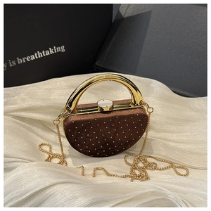 Détail du sac de soirée en acrylique avec strass blancs, poignée dorée et chaîne