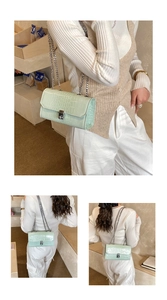 Detail of mint green crocodile embossed crossbody bag with silver chain and metal lock