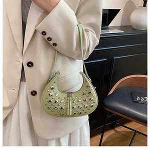 Detail of light green studded hobo bag with silver rivets and dual zipper closure