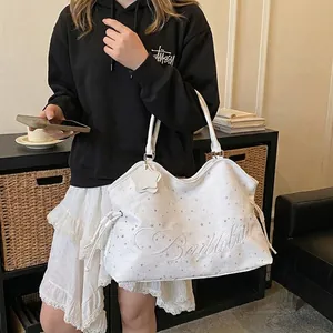 Grand sac cabas blanc à motif étoiles avec broderie affiché dans un décor d'intérieur