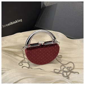 Vue détaillée du sac de soirée en velours rouge avec poignée argentée et perles
