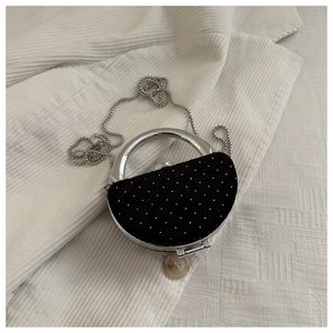 Détail de la pochette demi-lune en velours noir avec strass scintillants et poignée en argent