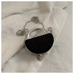 Détail du petit sac de soirée noir avec poignée en argent et bandoulière en perles