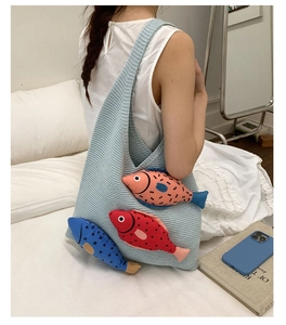 Détail du sac hobo en maille bleu clair avec trois accessoires de poissons en peluche 3D