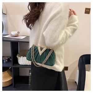 Détail du sac de soirée plissé vert émeraude avec boucle en strass étincelante en forme de V