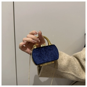 Détail du mini sac de soirée en velours bleu avec perles dorées et poignée en métal