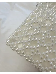 Détail de la pochette en perles tissées avec une doublure intérieure en satin blanc