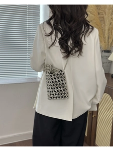 Mini sac bandoulière argenté perlé porté par un mannequin pour l'effet de taille