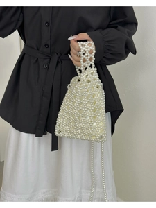 Détail du sac à main en perles blanches avec doublure satinée et anse tissée