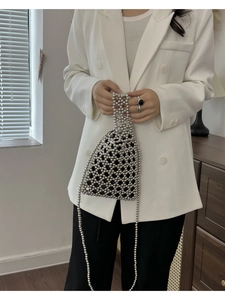 Détail du sac à main en perles argentées avec pochette noire et bandoulière perlée