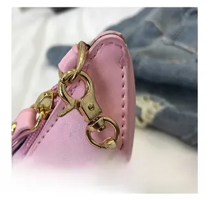 Nahaufnahme der rosa Ledertasche mit feinen Nähten und goldenen Metallhaken-Details