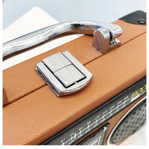 Gros plan d'un sac à main style radio rétro avec cuir marron et fermoir métallique