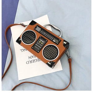 Gros plan du sac à main rétro en forme de radio avec texture litchi et poignée argentée