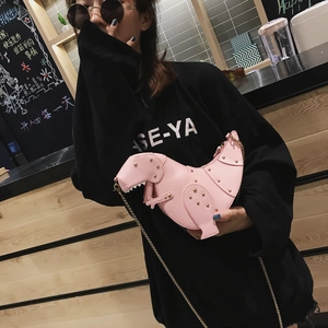 Detailaufnahme einer rosa Dinosaurier-Umhängetasche mit Goldnieten und einer Goldkette