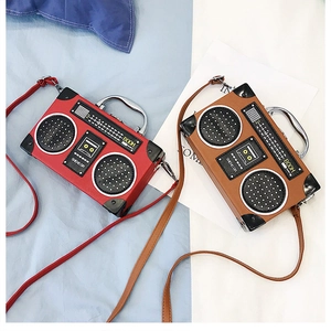 Détail de sacs à main forme radio vintage en rouge et marron avec poignées en métal
