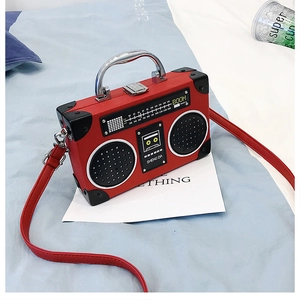 Détail du sac bandoulière radio vintage rouge avec poignée argentée et décorations